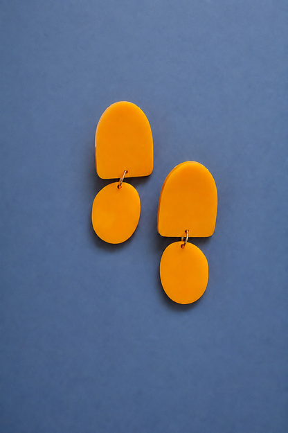 Ohrring in Orange auf blauem Hintergrund